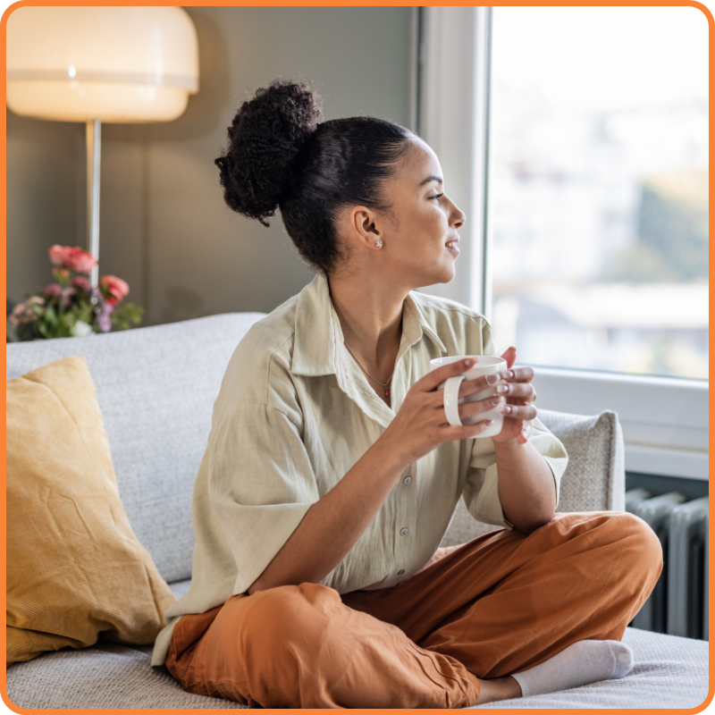Femme qui boit un café dans son canapé